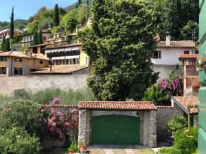 a green garage door in front of a village at Casa Angela in Toscolano Maderno