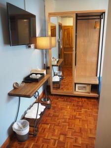 a room with a desk and a table with a mirror at Boonnark Bed Night Bazaar no car parking in Chiang Mai