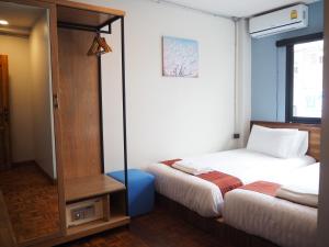 a bedroom with two beds and a mirror at Boonnark Bed Night Bazaar no car parking in Chiang Mai +14 photos