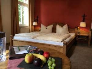 a bedroom with a bed with a tray of fruit on a table at waldhotel AUSZEIT in Tanne