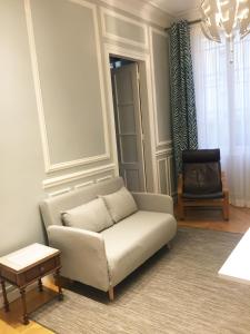 ein Wohnzimmer mit einem Sofa und einem Stuhl in der Unterkunft Residence sur Cour in Paris