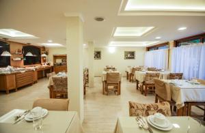 a dining room with tables and chairs in a restaurant at Pousada Das Papoulas in Gramado