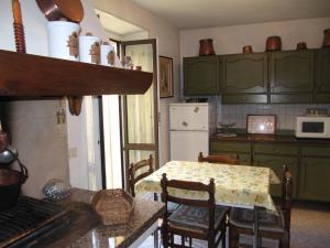 ガルニャーノにあるCasa Vacanze Gargnanoのテーブル付きのキッチン、緑のキャビネット付きのキッチン
