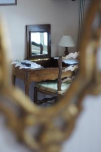 un miroir reflétant une chambre avec une table et une chaise dans l'établissement Hotel Montsegur, à Carcassonne