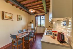 una cucina con tavolo e alcune sedie in camera di Casa Menco ad Arezzo