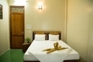 Una cama con dos toallas marrones. en Phong Nha Village House, en Phong Nha