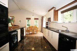 a kitchen with a sink and a dishwasher in it at Ballyhoura Mountain Lodges in Ballyorgan