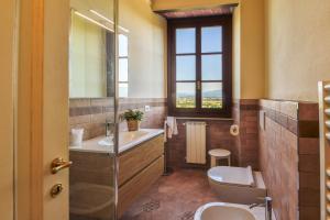 uma casa de banho com um lavatório, um WC e uma janela. em Casa Menco em Arezzo
