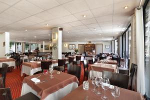 a dining room with tables and chairs and tablesktop at La Vanoise 1825 in Brides-les-Bains