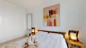 a white bedroom with a bed and two lamps at Casa Sofia in Costa Calma +19 photos