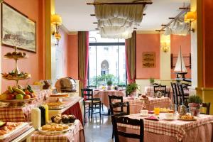 a restaurant with tables and chairs with food on them at Hotel Continental Genova in Genoa