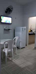 路易斯科雷亞的住宿－CONDOMÍNIO VENTO DO LITORAL，厨房配有桌子和白色冰箱。