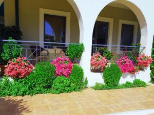 ein Haus mit rosa Blumen und grünen Büschen in der Unterkunft Eleana Boutique Hotel & Blue Infinity in Nikiana