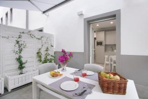 a white dining room with a table with a basket of fruit at Residence Dolcemare in Laigueglia