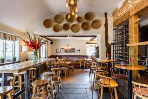 restauracja ze stołami i krzesłami oraz bar w obiekcie The George Inn w mieście Maulden