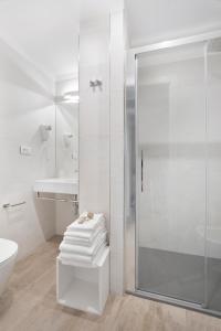 La salle de bains blanche est pourvue d'une douche et d'un lavabo. dans l'établissement Residence Dolcemare, à Laigueglia
