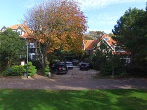 a group of cars parked in the driveway of a house at Villa Hoog Duin in Domburg