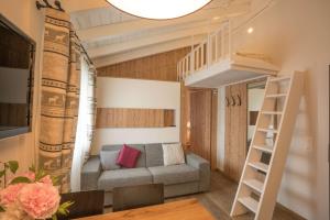 ein Wohnzimmer mit einem Hochbett und einem Sofa in der Unterkunft Hotel La Romantica in Le Prese, Poschiavo
