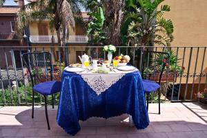 einen Tisch mit einem blauen und weißen Tischtuch in der Unterkunft Casa Vacanza AcquaMarina in Acireale