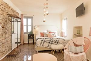 1 dormitorio con 1 cama y 1 silla en EL TORREON 109 CHARMING B&B - Recomendado Adultos en Frigiliana