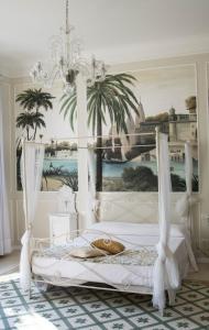 a bedroom with a white bed with a painting on the wall at Villa Verganti Veronesi in Inveruno