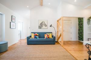 een woonkamer met een blauwe bank en een tapijt bij Chiado & Design Apartment in Lissabon