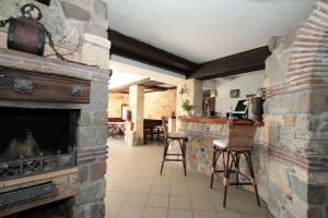 a living room with a stone fireplace and chairs at Villas Sozopol in Sozopol