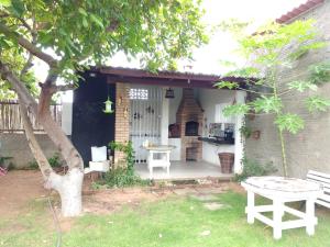 a patio with a table and a bench in a yard at Casa Guajiru in Guajiru