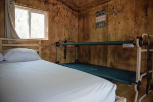 a bedroom with a white bed and a window at 11 Bridges Campground and Cabin Park in Rosedale