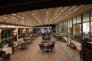 a restaurant with tables and chairs and lights on the ceiling at Mirador Hotel in Ramallah