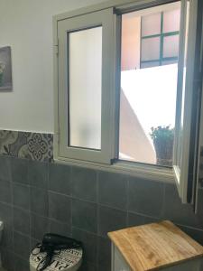 a bathroom with a toilet and a window at Be in Sicily in Syracuse