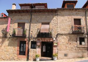 un antiguo edificio de piedra con 2 balcones. en La Casona de Lucía, en Sigüenza