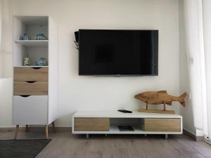 a living room with a tv on a wall at Apartments 4you in Vir