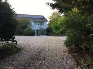 Uma casa branca com um banco à frente. em Private luxury retreat em Sible Hedingham