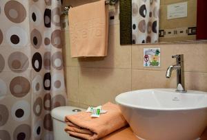 a bathroom with a sink and a toilet at Hostal Terra 3 - BASE AÉREA in Quito