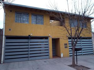 a house with two garage doors in front of it at Los Nietos hospedaje in Mendoza