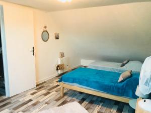 a bedroom with a blue bed and a cross on the wall at CosyStudio2 Site du Futuroscope in Jaunay-Marigny