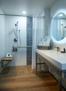 a bathroom with a shower, sink, and mirror at Hard Rock Hotel Daytona Beach in Daytona Beach
