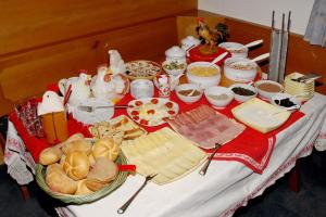 uma mesa com um buffet de queijo e outros alimentos em Garni Waldfrieden em Castelrotto