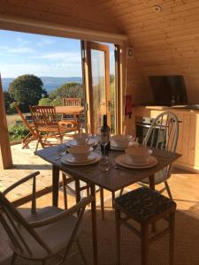 une table en bois avec des assiettes et des verres dans l'établissement Sutor Coops The Nest with Hot Tub, à Cromarty