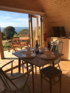 a wooden table with plates and glasses on it at Sutor Coops The Nest with Hot Tub in Cromarty