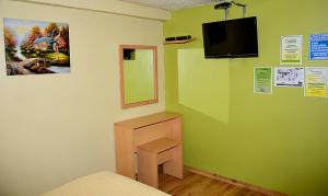 een kamer met groene muren en een bed en een spiegel bij Hostal Terra 4 - EL LABRADOR in Quito