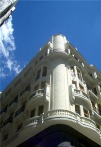 un gran edificio blanco con una torre encima en Hostal Excelsior, en Madrid