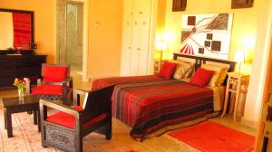 a bedroom with a bed and a table and a chair at Dar Kamango in Marrakesh