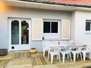 a patio with a white table and white chairs at CosyStudio2 Site du Futuroscope in Jaunay-Marigny