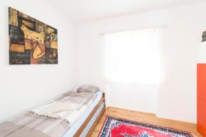 1 dormitorio con cama, ventana y alfombra en Cà Ala Cros, en Gerra Verzasca