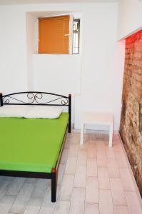 a green bed in a room with a brick wall at Hostel Train Station in Kyiv