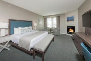 a hotel room with a large bed and a fireplace at Anchorage by the Sea in Ogunquit