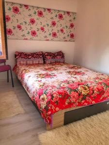 a bedroom with a bed with a red floral bedspread at Casa Simion in Sibiu