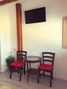 three chairs and a table with a tv on a wall at Casa Simion in Sibiu